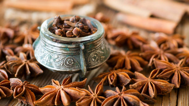Christmas aromatic spices on a rustic background. Clove, cinnamon in sticks, anise illicium on old wooden table. Christmas and winter cocktail spices