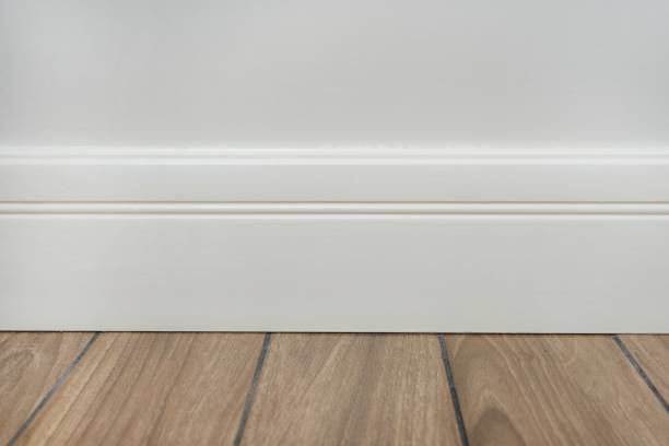 istock Light matte wall, white baseboard and tiles immitating hardwood flooring 936301204