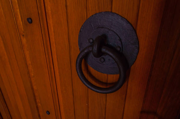 The metallic ornament lock on the old wooden door in the home