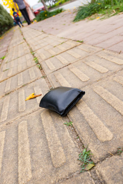 istock lost wallet on sidewalk with people going far away 936302524
