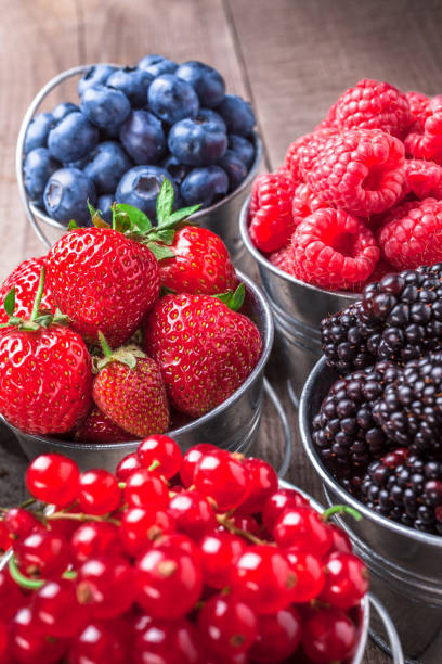 istock Berries assortment close-up in tin cans on rustic wooden table 936308616