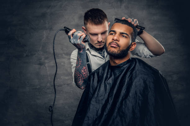 istock Male barber cutting the beard to Black stylish man. 936309048