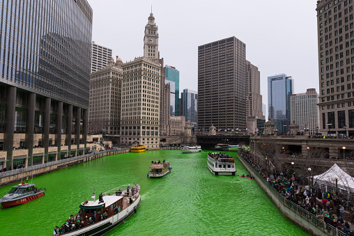 Chicago, USA – Mar 17, 2018: Early in the morning the River turned green by the plumbers local 130. Every Year following tradition they pour orange dye that turns the river green for the annual Saint Patrick’s Day celebration. The tradition stretches back to 1962 when Mayor Daley was trying to get to the bottom of the pollution problem in the Chicago river. They developed a green dye that would show the dumping was occurring. It developed into a long standing celebration and tradition. Hundreds of thousands of people crowd the river every year to watch.