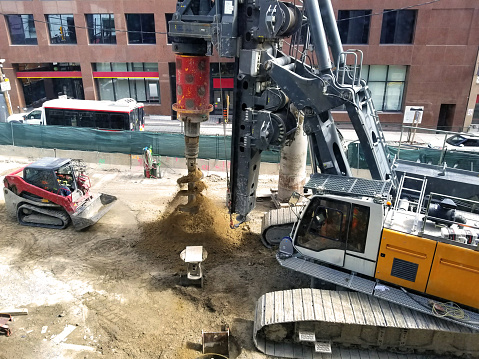 Giant rotary drilling machine that is being operated on a street construction site
