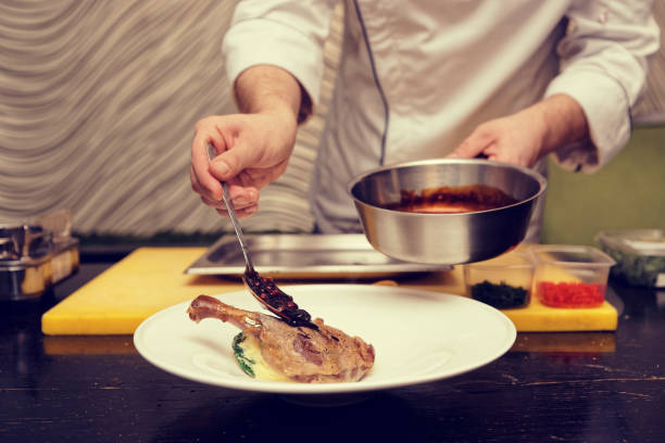 istock Chef is adding berry sauce to poultry dish, blue tone 936312236