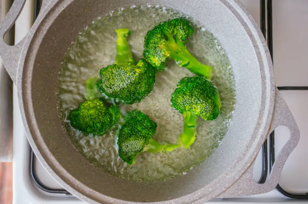 morceaux de brocoli frais cuisent au bain-marie dans une casserole. alimentation saine pour les enfants et l’alimentation. - salad green pouring dip photos et images de collection