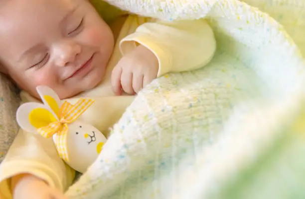 Photo of Cute little baby sleeping with decorative egg toy