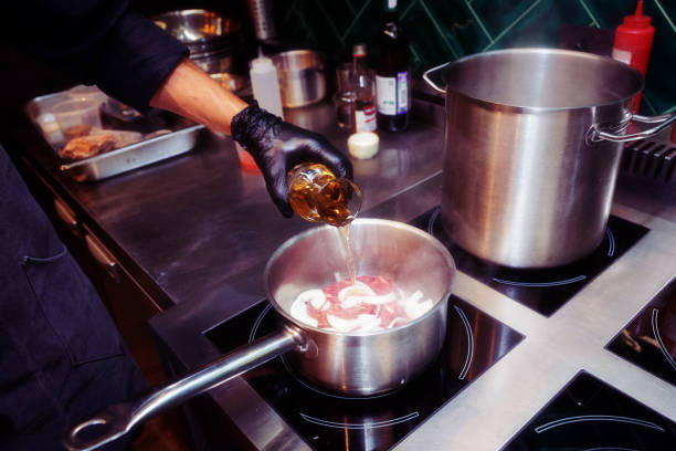 istock Chef is adding white wine to a dish, toned, noisy, grainy 936320842
