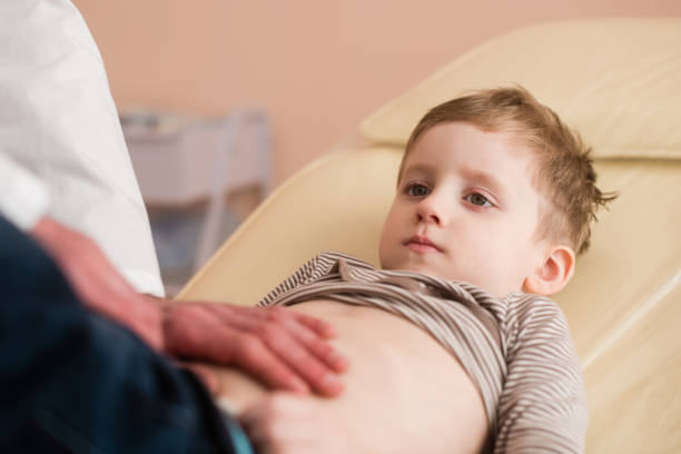 маленький мальчик на медицинском осмотре - belly button стоковые фото и изображения