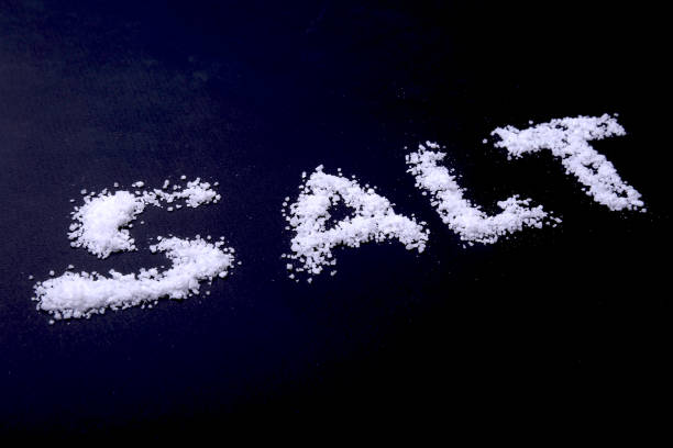 istock White sea salt isolated on a black background. Selective focus. 936328996