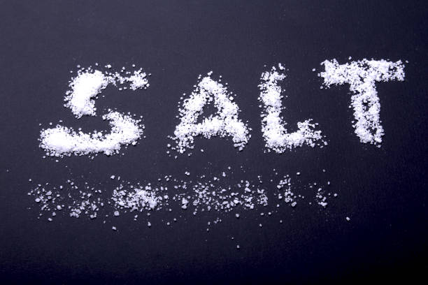 istock White sea salt isolated on a black background. Selective focus. 936329144