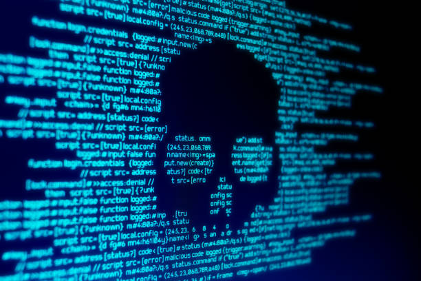 Computer Malware Attack Computer code on a screen with a skull representing a computer virus / malware attack. ransomware stock pictures, royalty-free photos & images