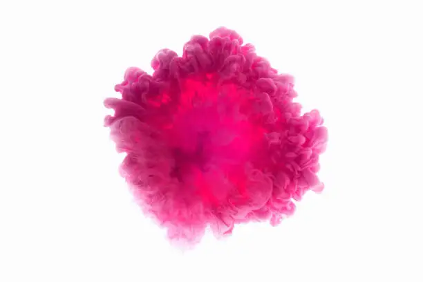 Photo of Color drop in water, photographed in motion. Abstract swirling. Cloud of silky bulb under water isolated on white background. Pink paint