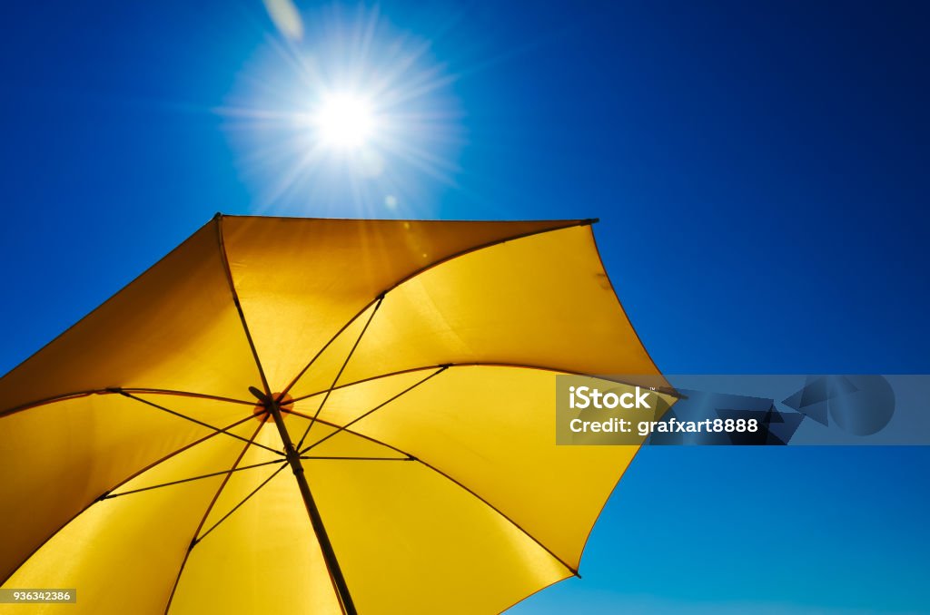 Yellow Umbrella With Bright Sun And Blue Sky Sun Stock Photo