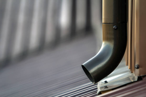 istock Brown new gutter metal system pipe. Vertical construction for draining rain water from building roof on the wall. Drain protection. 936343250