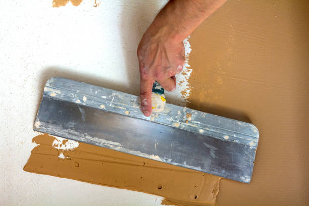 Renovation workers hand plastering the wall Renovation workers hand plastering the wall stucco repair stock pictures, royalty-free photos & images