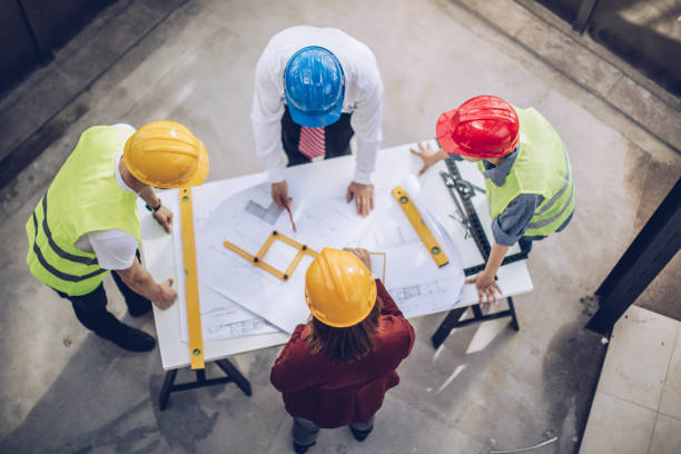 Architects working together at construction site Construction workers and architects working on construction site commercial renovation stock pictures, royalty-free photos & images