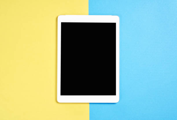 istock Top view; Modern workplace with tablet placed on a pastel yellow background. Copy space suitable for use in graphics. 936348264