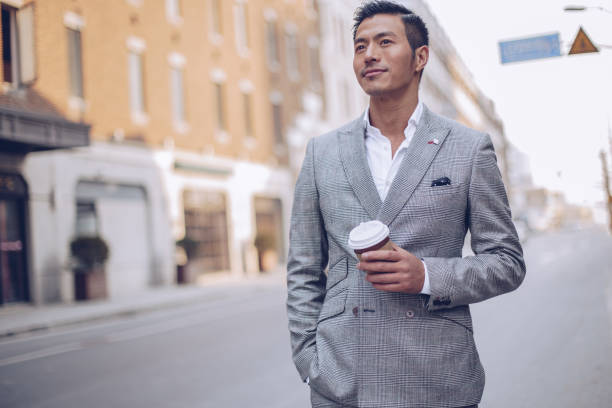 istock Handsome businessman drinking coffee on the street 936348952