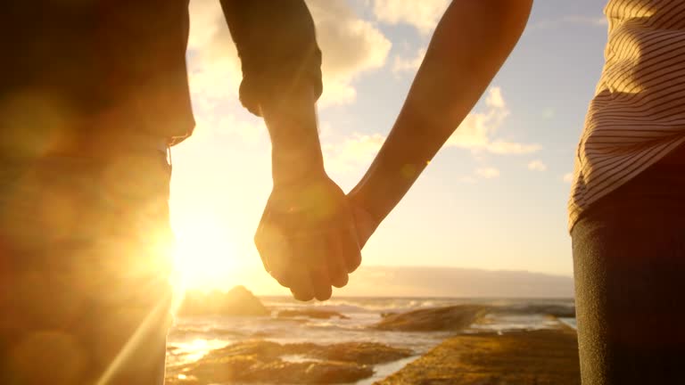 Couple walking hand in hand on the beach 4k