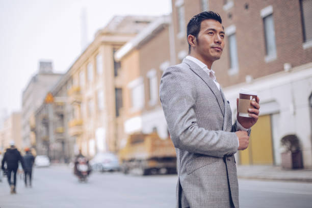 istock Handsome businessman drinking coffee outdoors 936349544