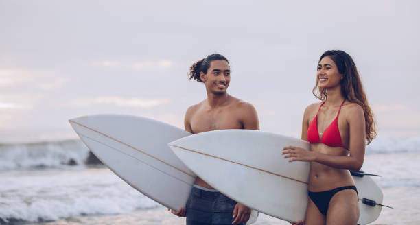 istock Young couple with surfboards at the beach 936349592