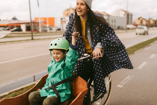 Cargo bike ride on the rain Mother and son having a ride with cargo bike on the rain cargo bike photos stock pictures, royalty-free photos & images