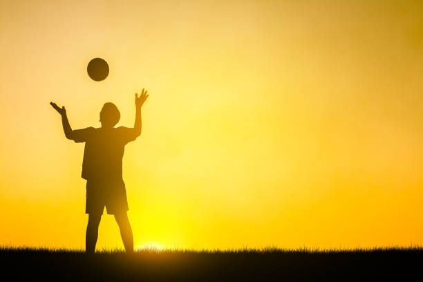 istock Football kid in nature silhouette. 936351392