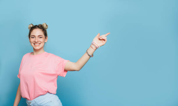 istock modern young woman pointing copy space and smiling 936352516