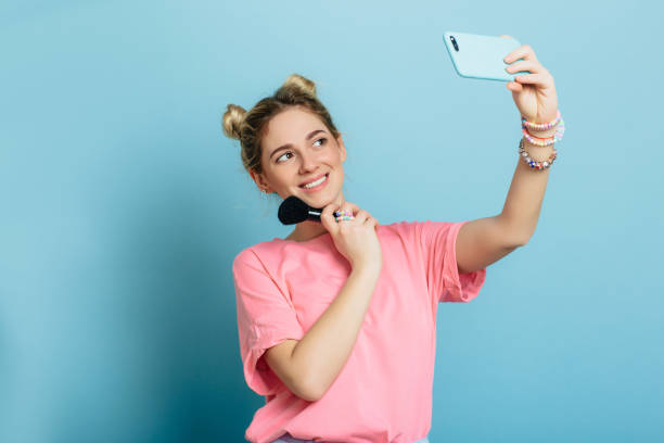 istock trendy woman - making selfie at blue background 936352530