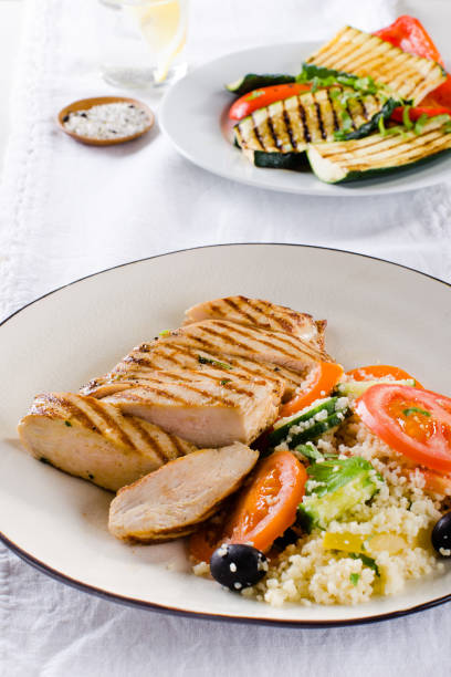 istock Grilled chicken breast with tabbouleh salad and grilled vegetables on white 936353482