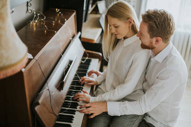 istock Loving couple playing piano. 936355420