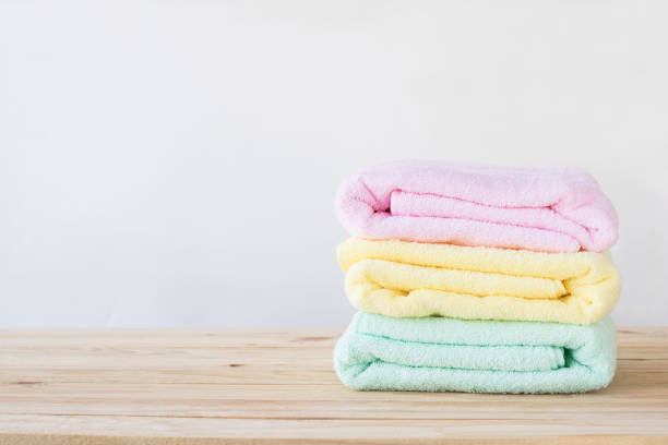 istock towel on wood table with white wall and copy space, can be used for present products 936356028