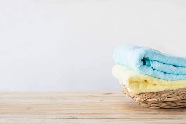 istock towel on basket on wood table with white wall and copy space, can be used for present products 936356030