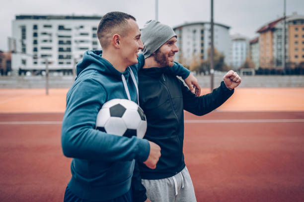 istock Best friends playing socceer on streets 936360118