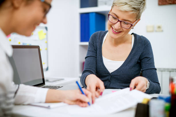 istock Two charming stylish middle aged business women working together while sitting one across another in the office. 936365408