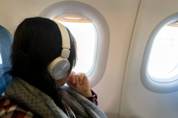 istock girl sitting beside window on plane 936367404