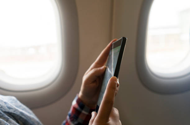istock girl reading smart phone on plane 936367408