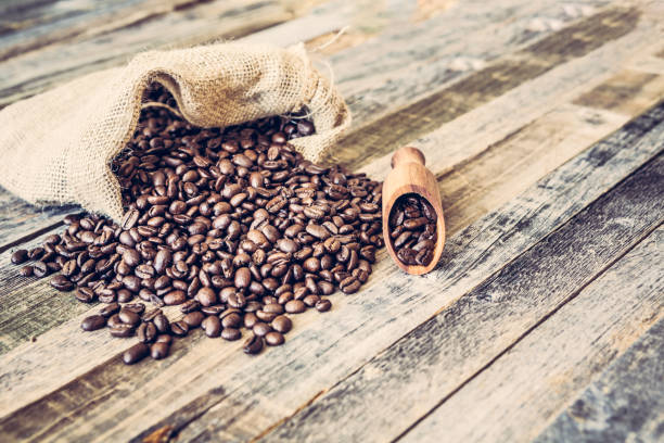 istock Roasted coffee beans in a bag on wooden background 936369450