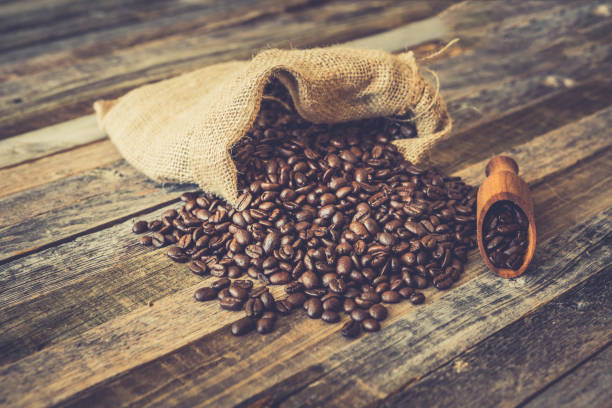 istock Roasted coffee beans in a bag on wooden background 936369478