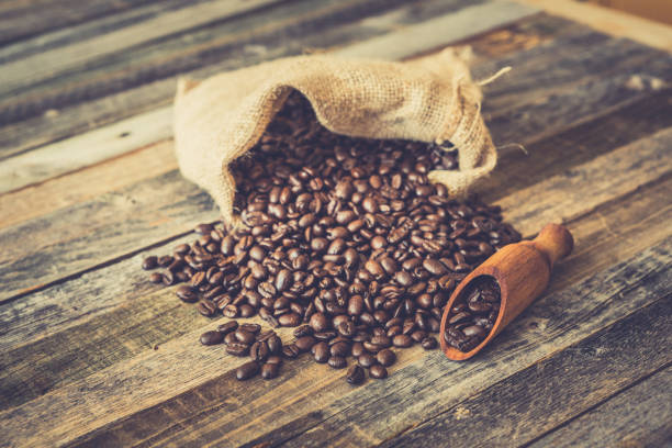 istock Roasted coffee beans in a bag on wooden background 936369510