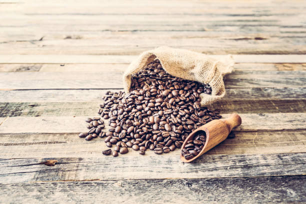 istock Roasted coffee beans in a bag on wooden background 936369554