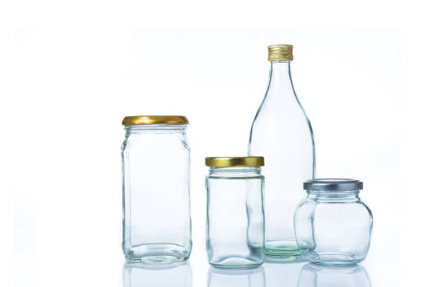 istock Empty clear glass bottles in various sizes and shapes with lids on white background 936369808