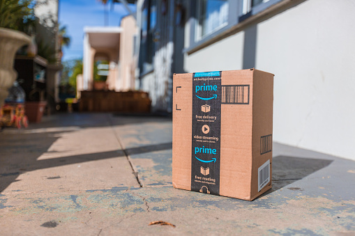 Los Angeles CA, November 11/22/2017: Image of an Amazon packages. Amazon is an online company and is the largest retailer in the world. Cardboard package delivery at front door during the holiday season. shipping package parcel box on wooden floor with protection paper inside. Amazon.com went online in 1995 and is now the largest online retailer in the world.