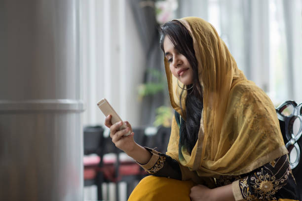 Muslim woman with mobile phone in the room. Muslim woman with mobile phone in the room. pakistani ethnicity stock pictures, royalty-free photos & images