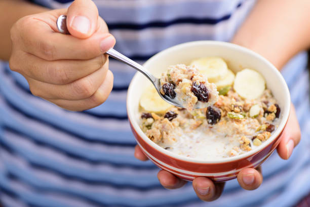 istock Muesli cereal in a bowl holding by hand and eating 936378390