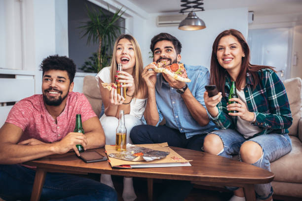 istock Friends eating pizza and watching tv 936378680
