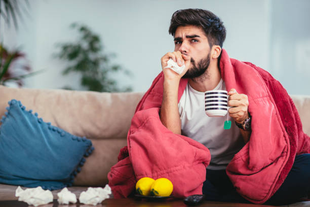 istock Young ill man drinking hot tea at home 936378726
