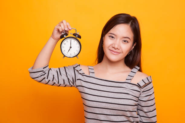 istock Young Asian woman with a clock. 936379008