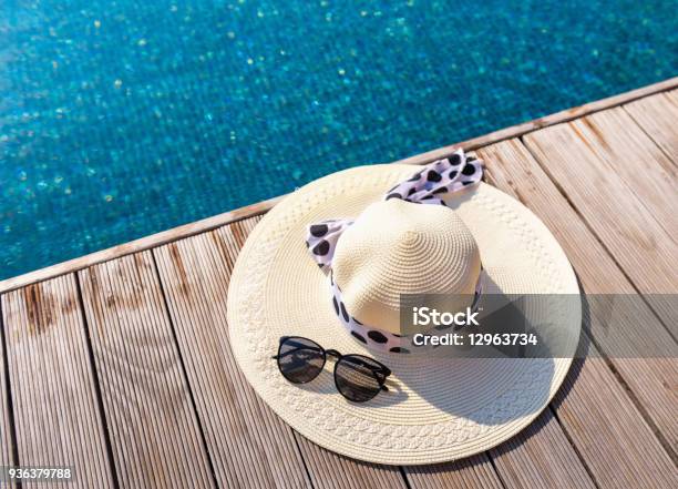 Straw Sun Hat And Sunglasses On The Terrace Of Swimming Pool Stock Photo - Download Image Now